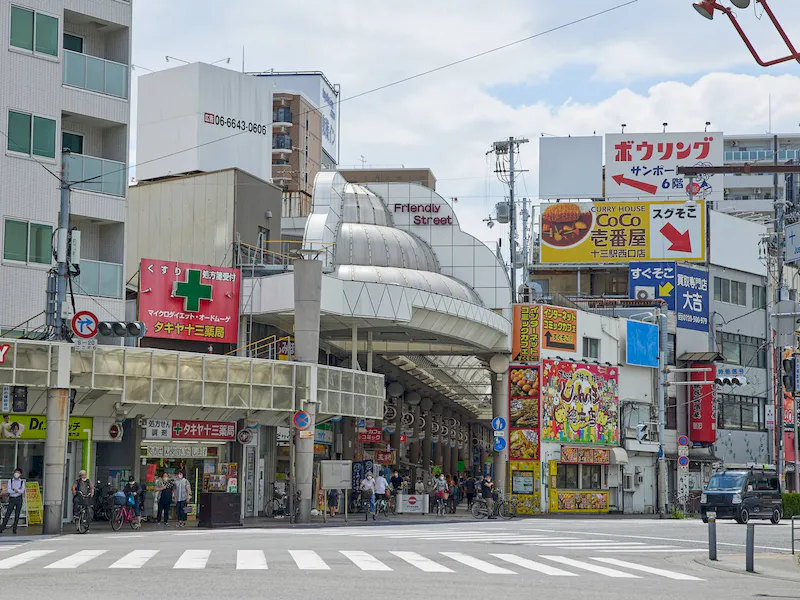 阪急十三駅西口改札よりスグ、駅前メインストリートの十三フレンドリー商店街。